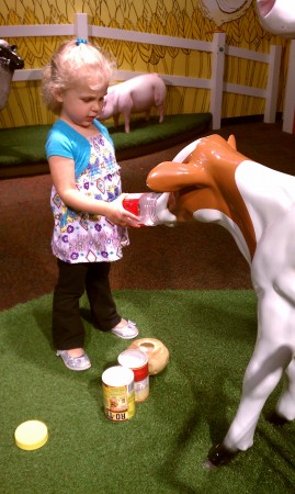 Pretending to feed the cows at the Omaha Children's Museum.